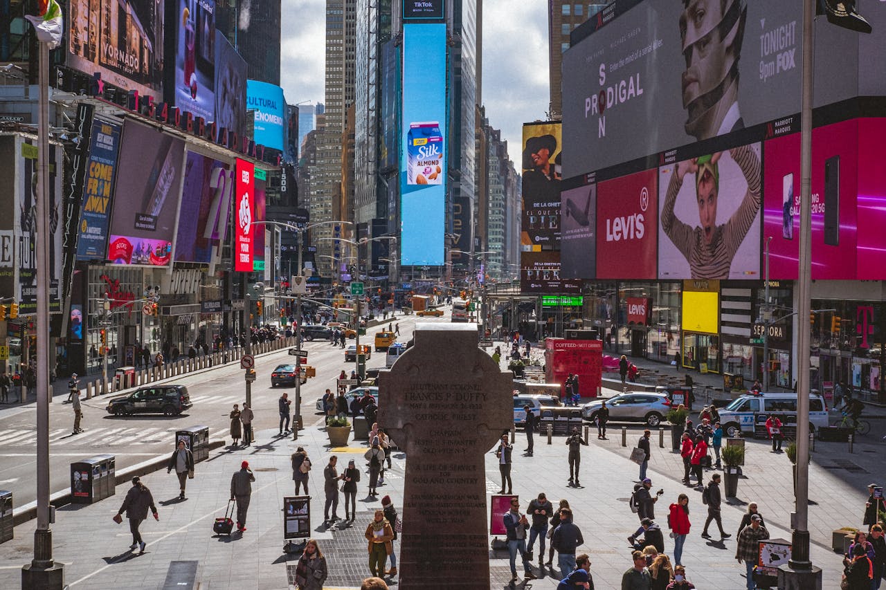 Bustling Times Square, NYC, captures urban life with crowds, traffic and billboards.